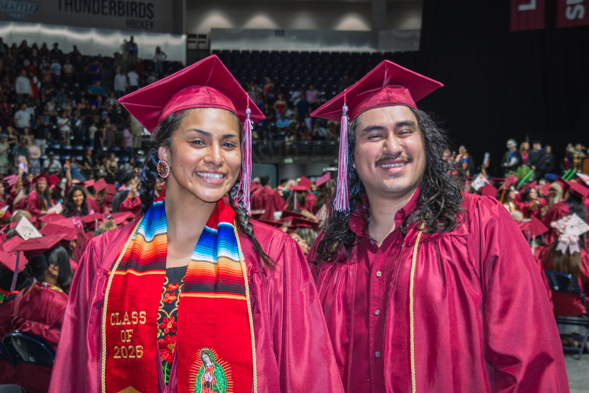 Two graduates smiling at Commencement