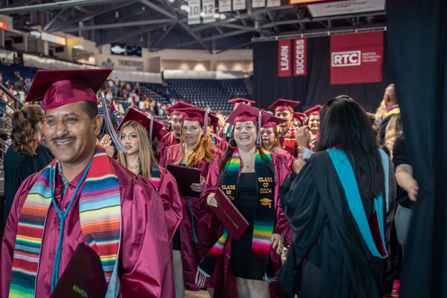 students graduating at the Showare Center, smiling as they exit 