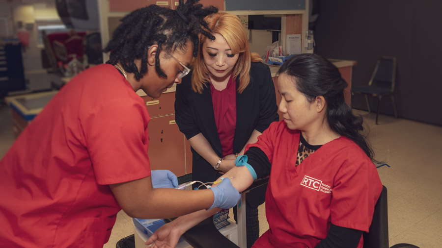 Phlebotomy program students practicing drawing blood