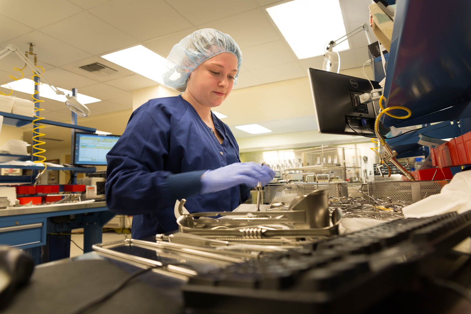 A central service technician preparing medical instruments for use.