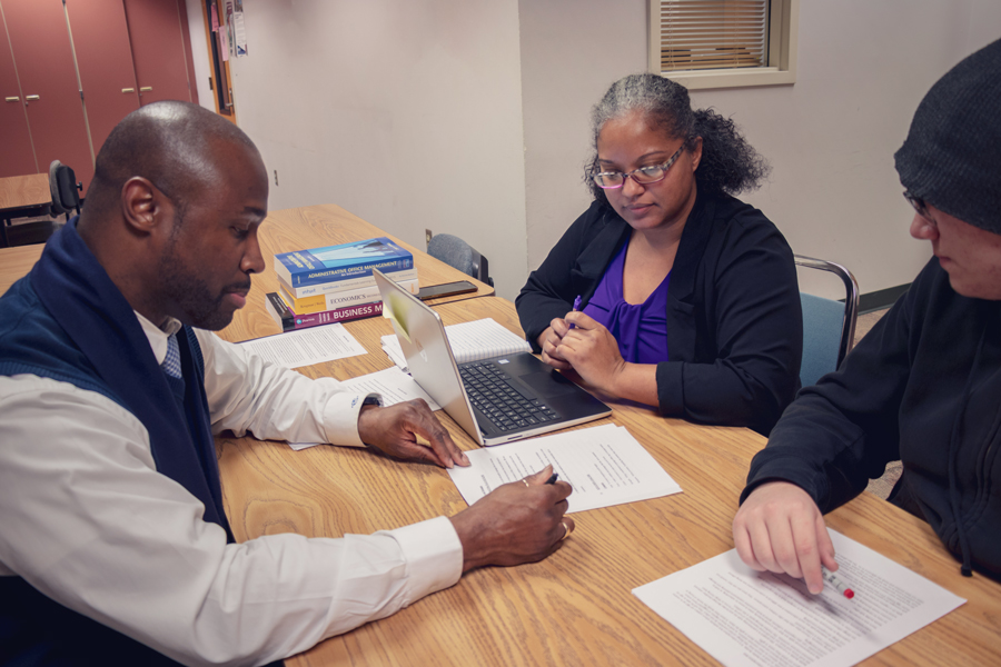 Three people at a table working on a contract.