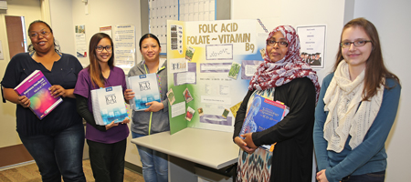 Five health care workers presenting a science project.